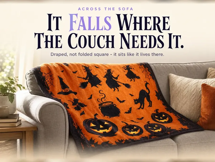 The throw draped loosely across a sofa's arm and back cushions in afternoon light.