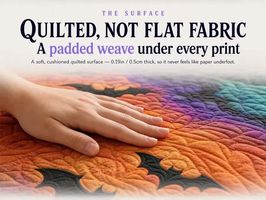 A hand pressing into the padded quilted texture of the illusion rug's surface, print visible beneath.