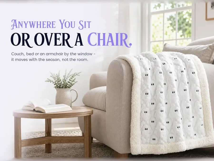 The throw folded over the arm of a reading armchair beside a window in daylight.