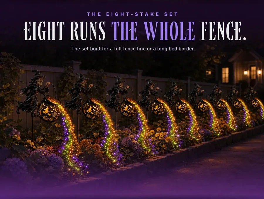 Eight matching cauldron stakes spaced along a garden fence line at night